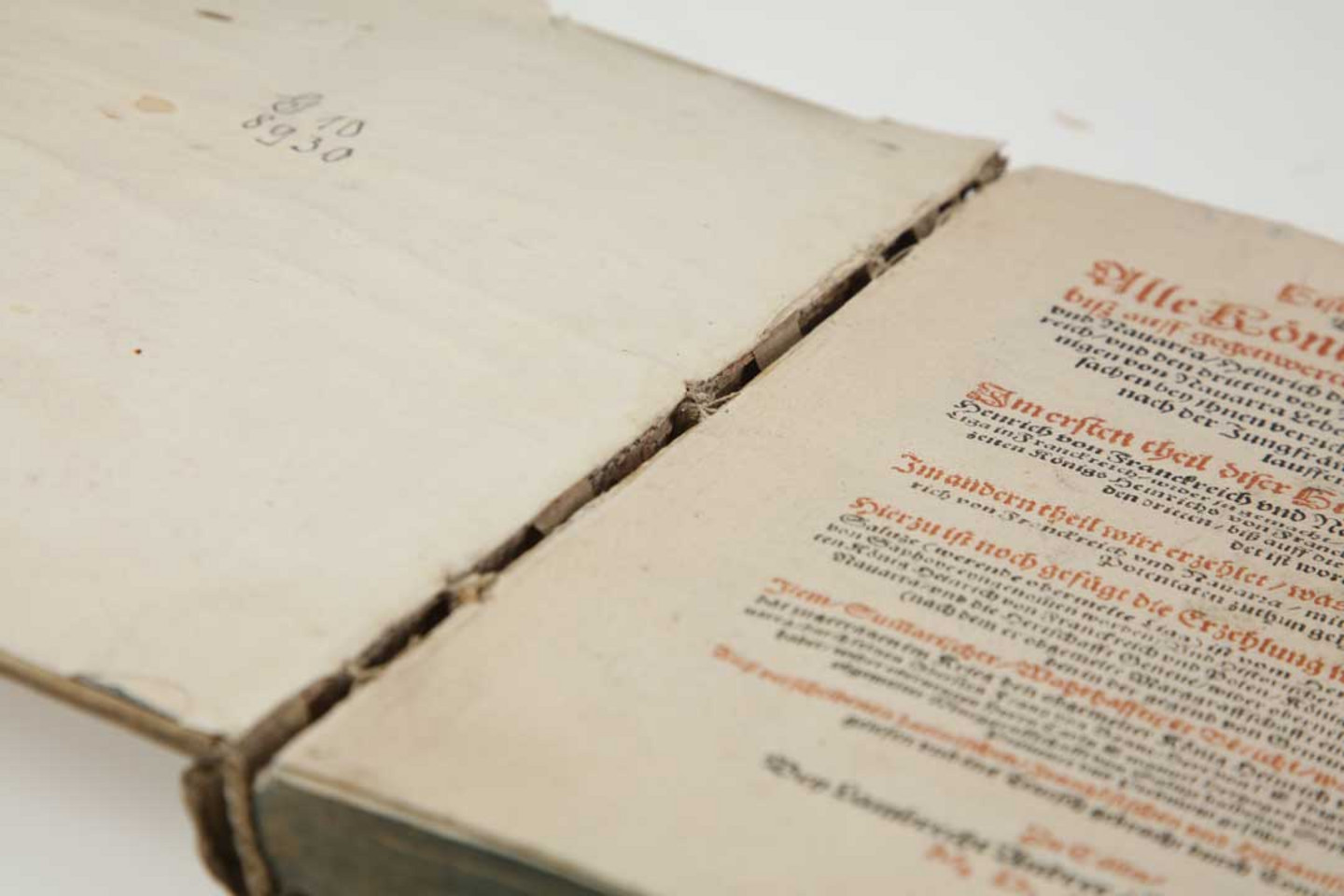 Foto eines beschädigten Buches aus dem Jahr 1597: Löw, Conrad: Historie von Nauarra [Navarra]. Cölln: Lambrecht Andree 1597. Signatur: G10/8930. Die Projektnummer lautet 2022/0014