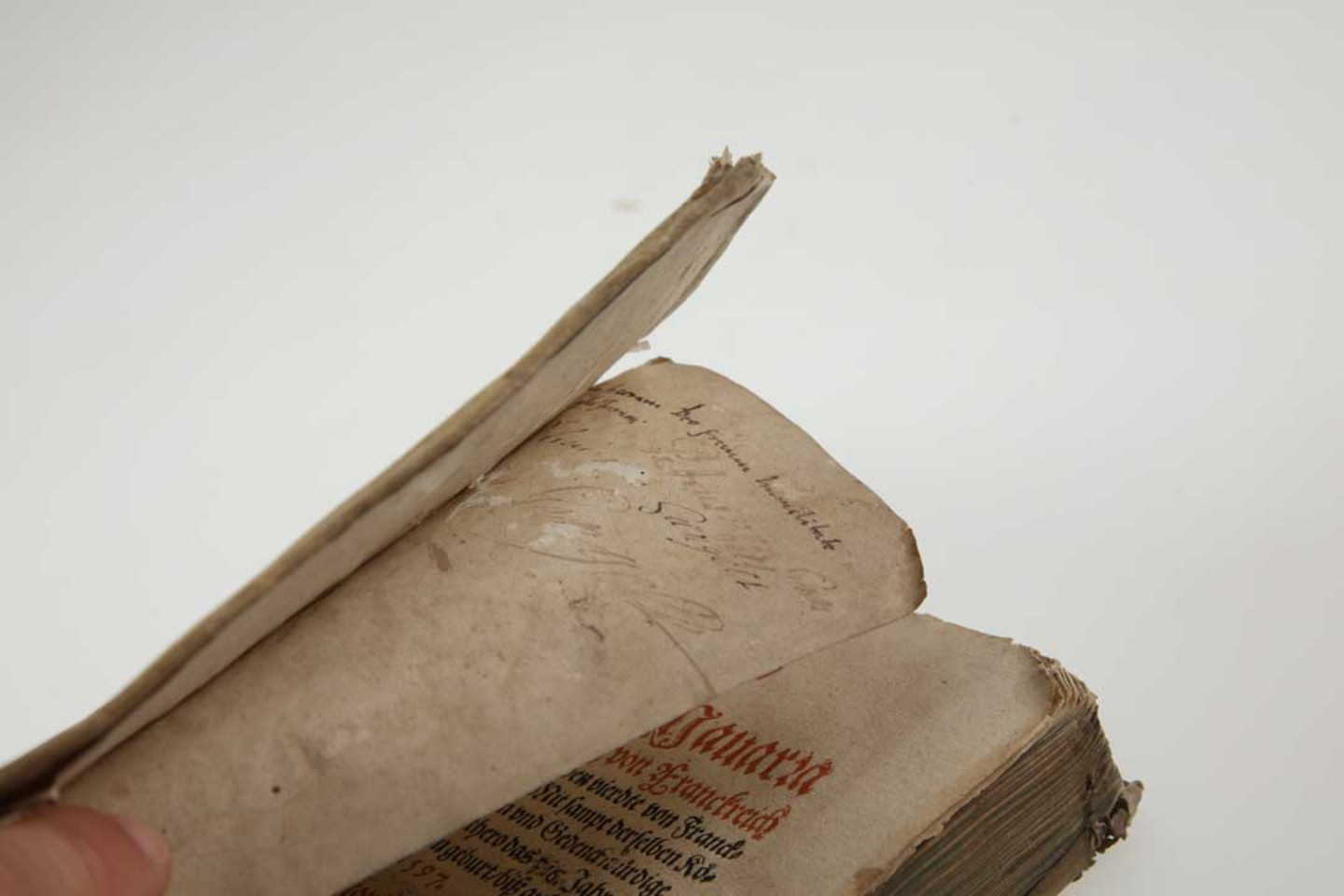 Foto eines beschädigten Buches aus dem Jahr 1597: Löw, Conrad: Historie von Nauarra [Navarra]. Cölln: Lambrecht Andree 1597. Signatur: G10/8930. Die Projektnummer lautet 2022/0014